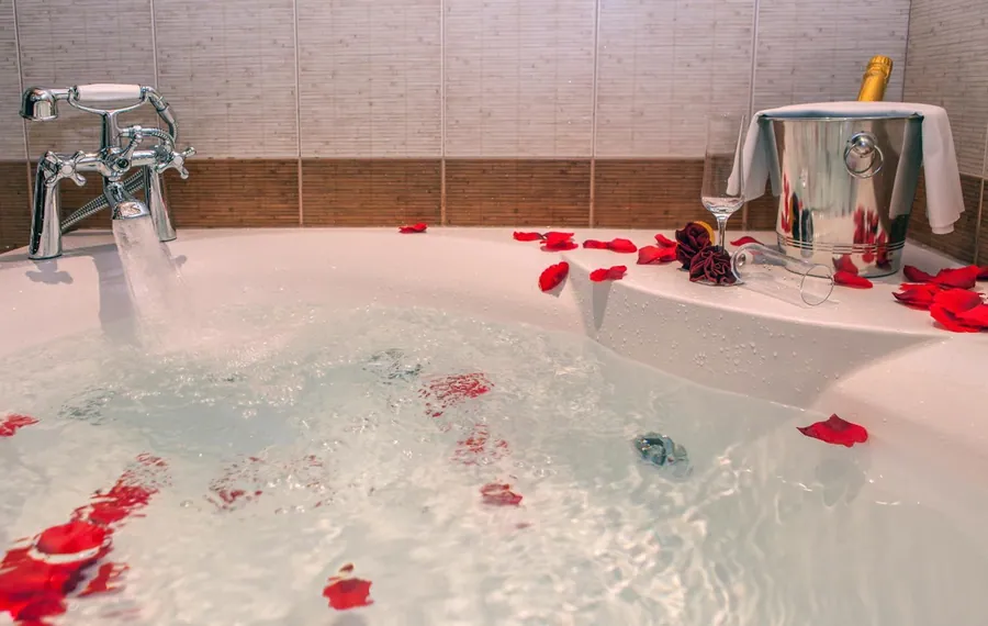 Jacuzzi με ροδοπέταλα στο νερό και σαμπάνια σε παγοθήκη